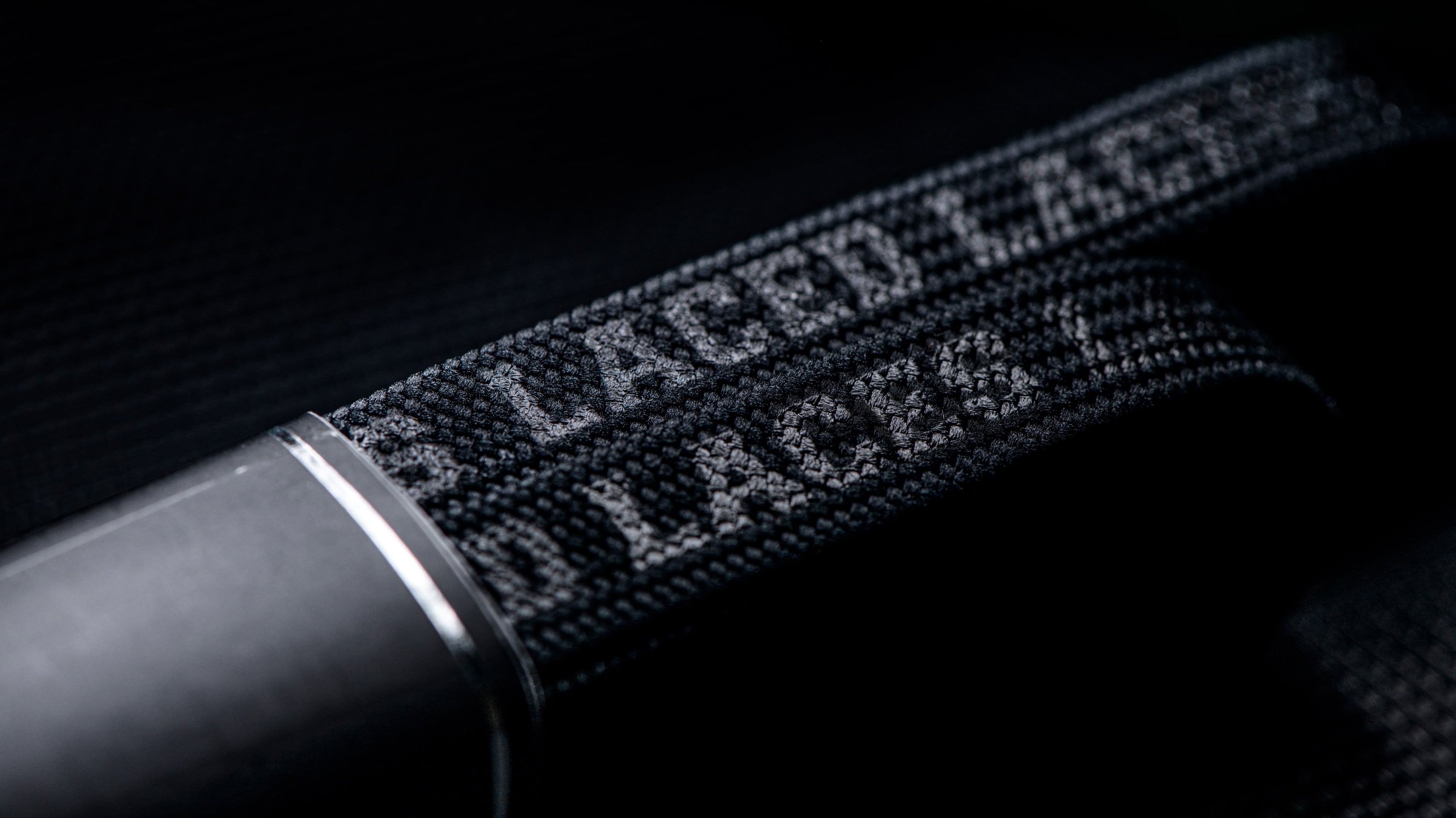 Close up of Laced Waxed Laces - Stealth Black, showing how the words glow in the light.